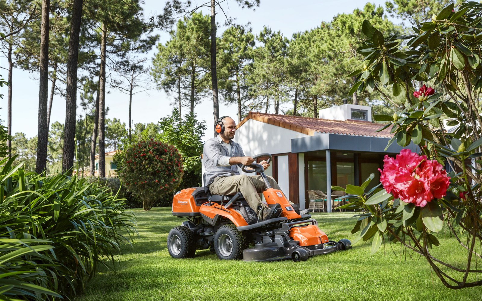 Rasentraktor bei der Arbeit in einer Gartenanlage