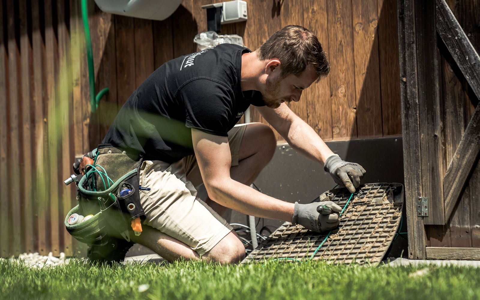 Mitarbeiter bei der Installation eines Mähroboters im Garten